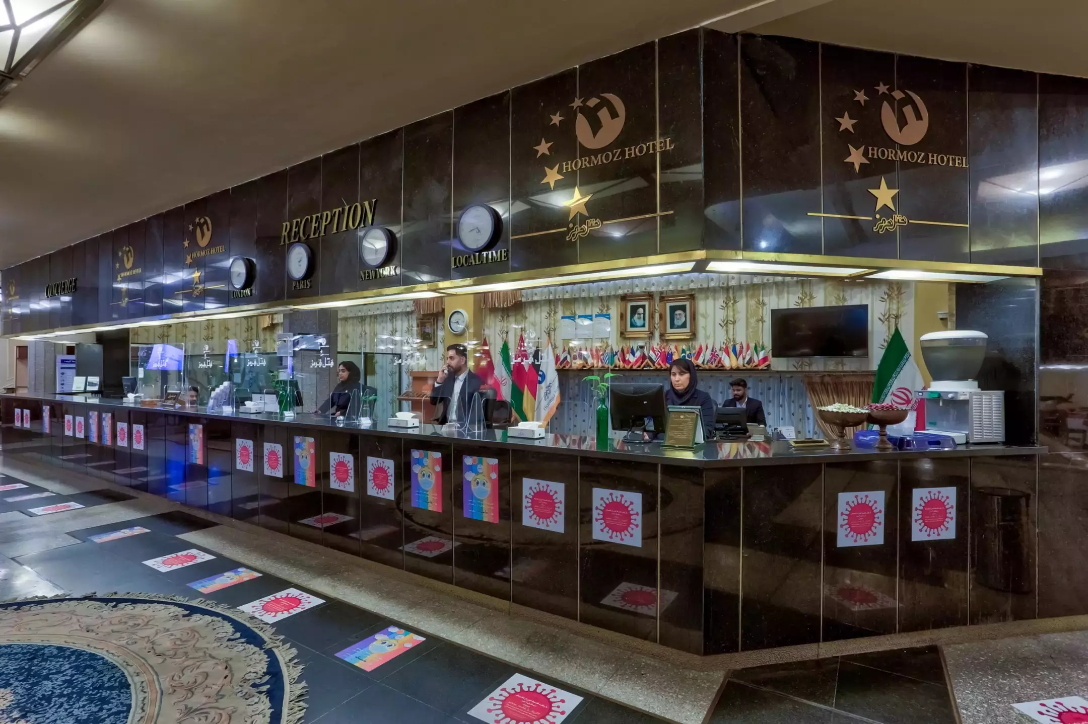 پیشخوان پذیرش هتل هرمز با کارکنان و پرچم‌ها