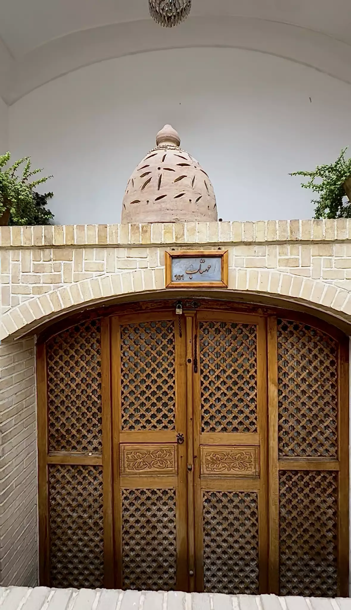در چوبی مشبک اقامتگاه صباغیان زیر گنبد آجری