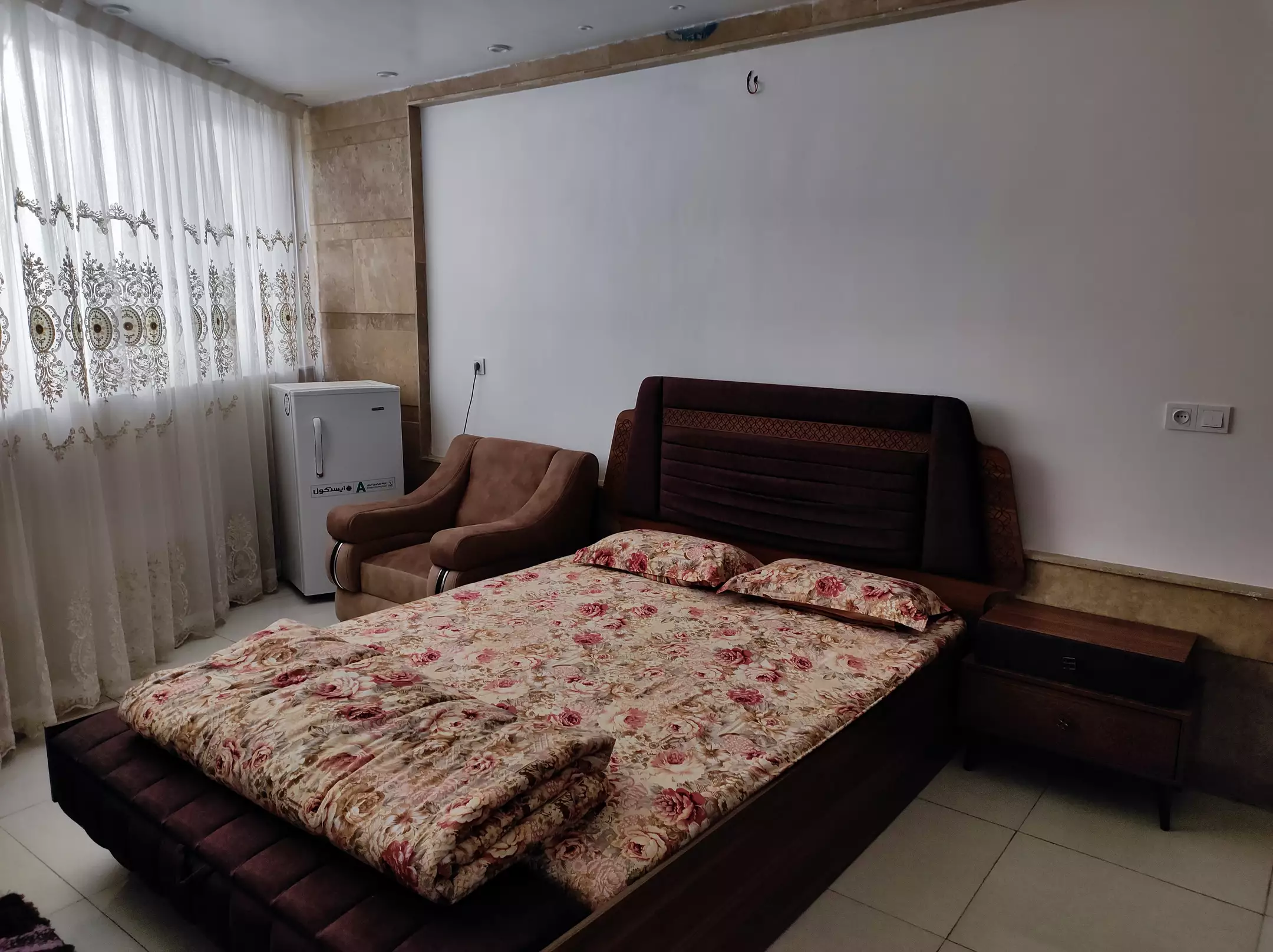 تخت دونفره با روتختی گل‌دار هتل آرامش
