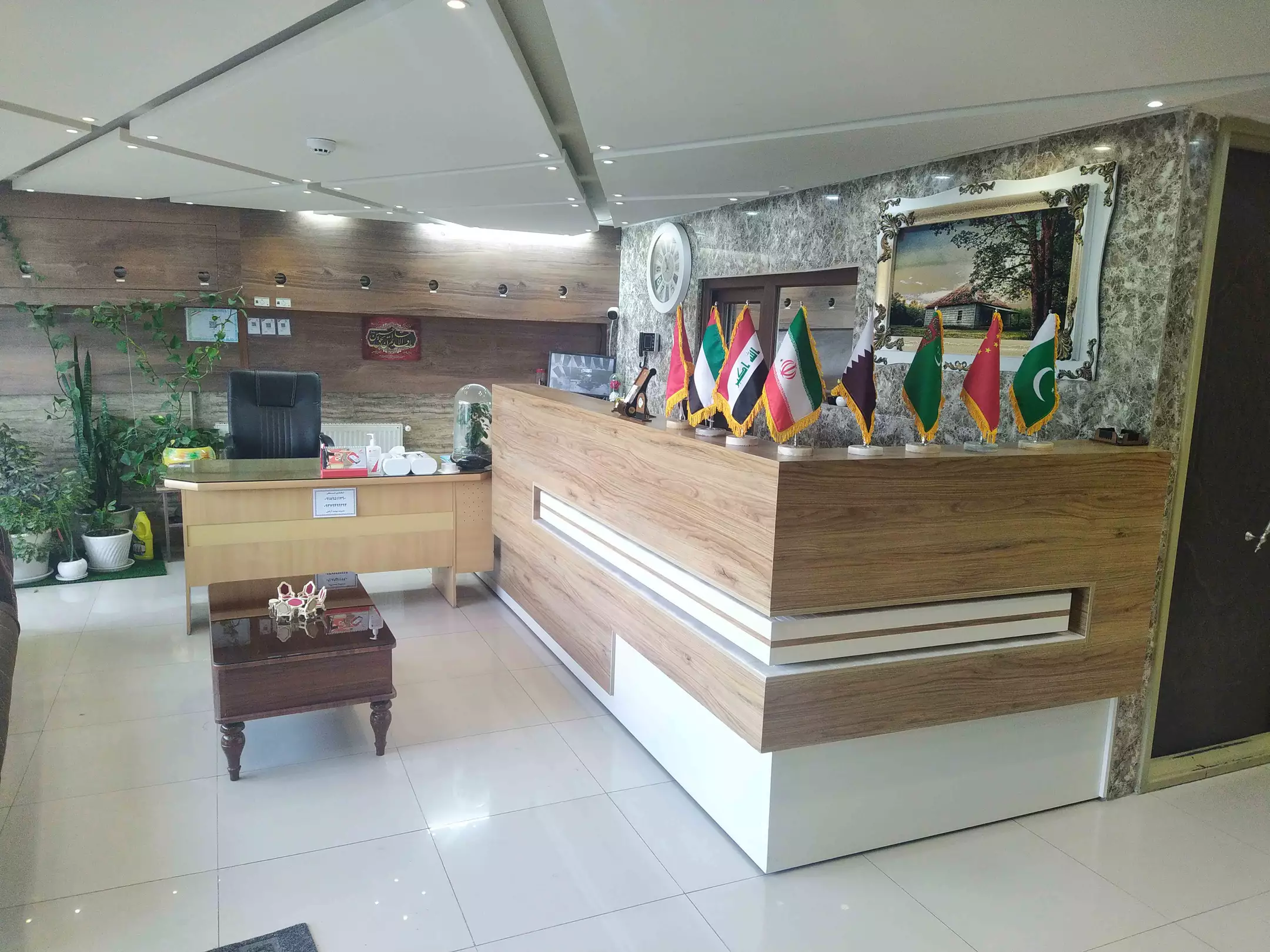 پذیرش هتل آرامش با میز چوبی و پرچم‌ها