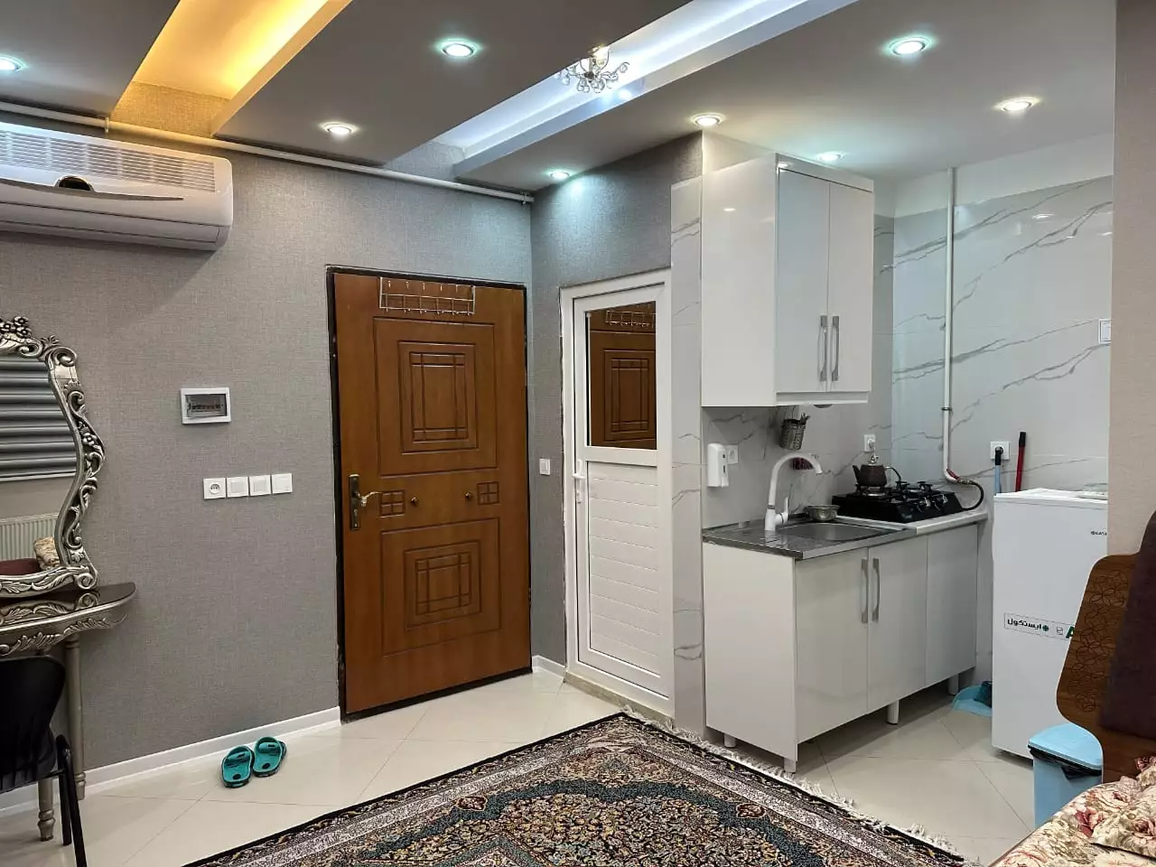 آشپزخانه کوچک هتل آرامش با کابینت سفید و اجاق