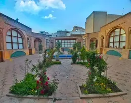 حیاط هتل ارغوان قزوین با باغچه‌های گل‌کاری‌شده