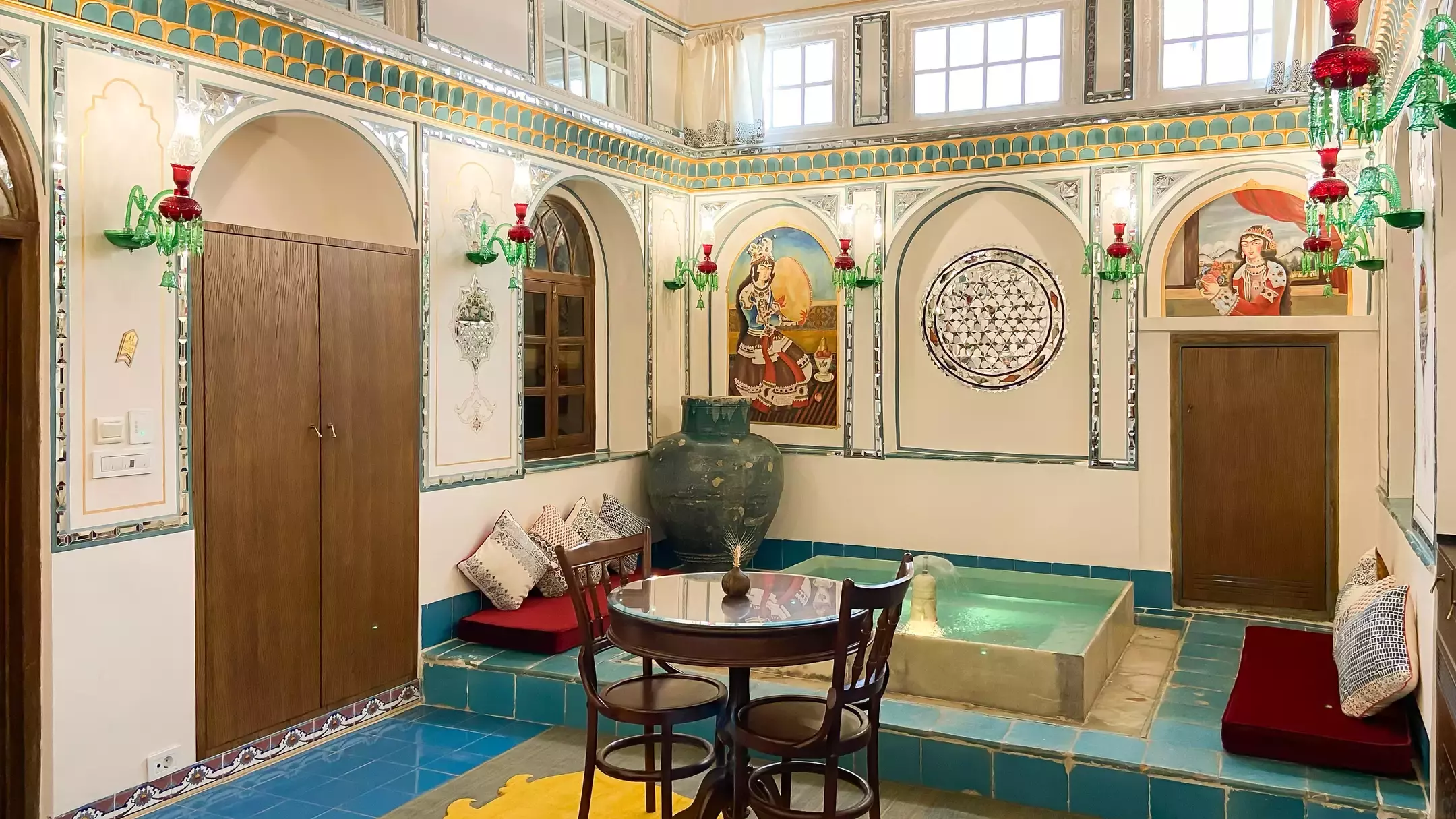 فضای نشیمن عمارت شهسواران با حوض و میز گرد