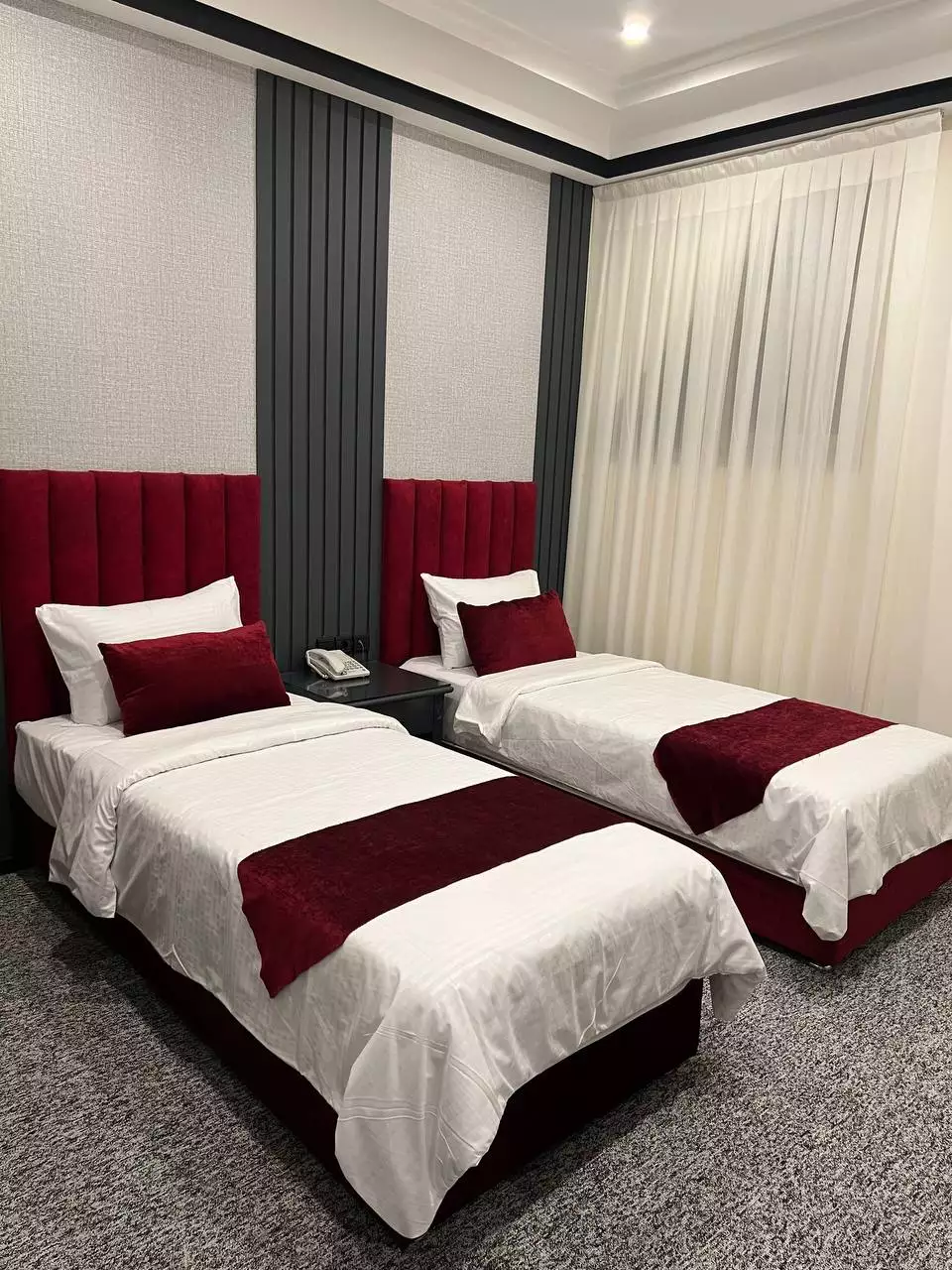 اتاق دوتخته هتل سایه با تخت‌های زرشکی