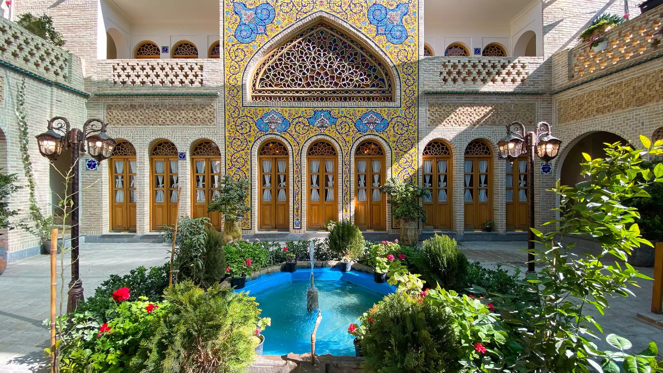 حیاط هتل گل آرا با حوض آبی و کاشی‌کاری سنتی