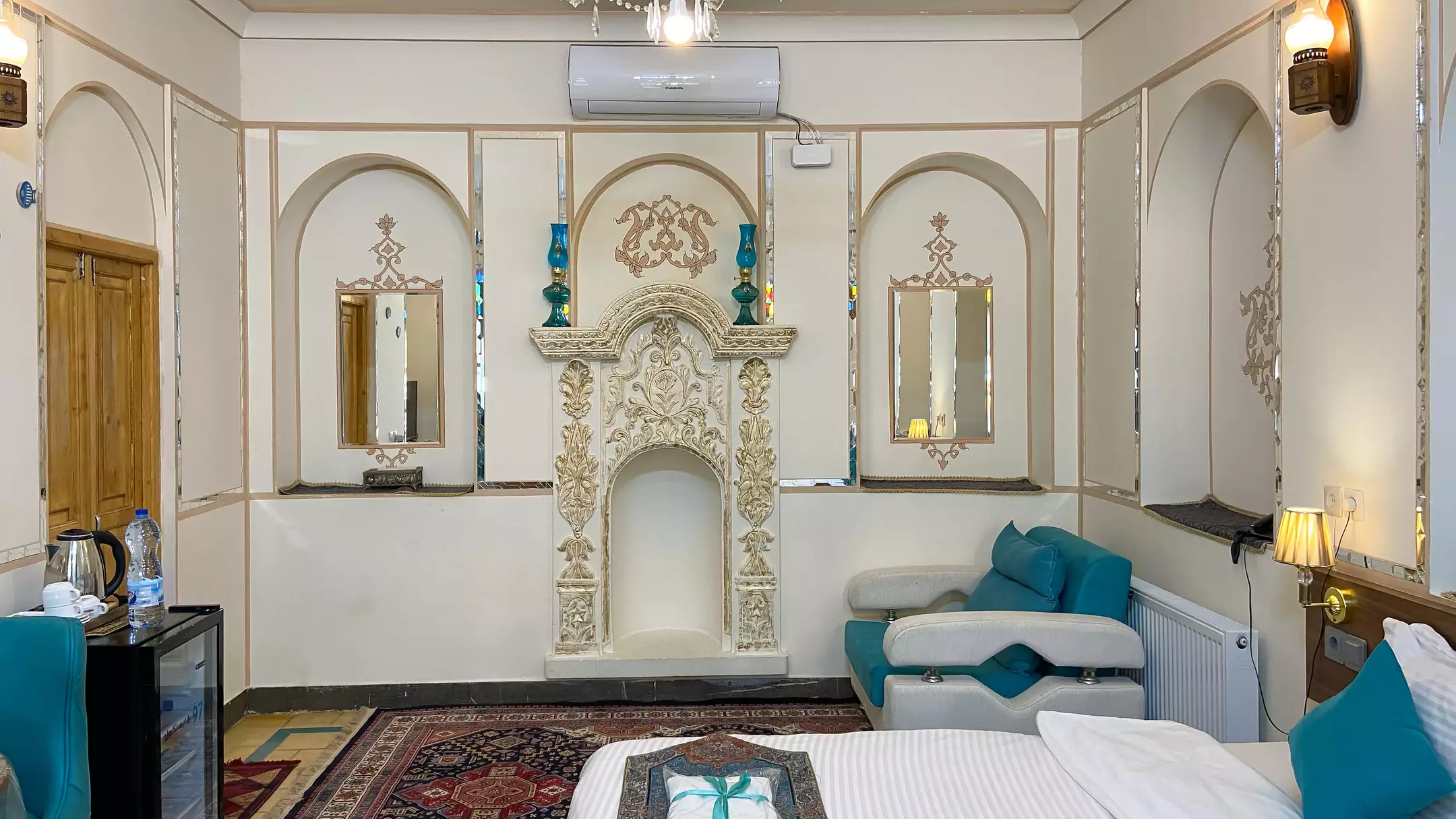 اتاق هتل گل آرا با شومینه گچ‌بری و تخت