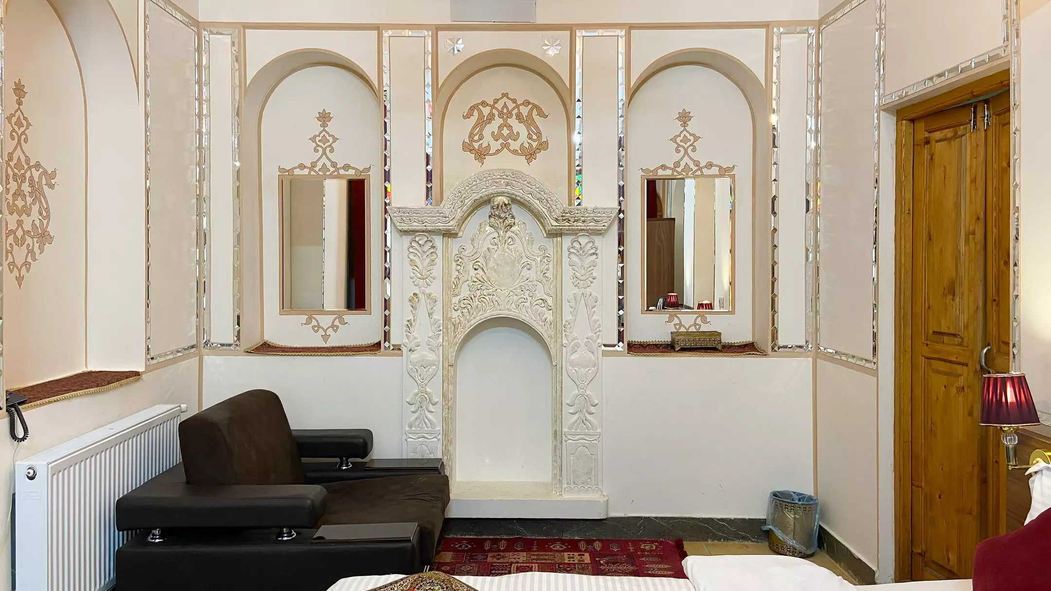نشیمن گل آرا با شومینه گچ‌بری و مبل چرمی