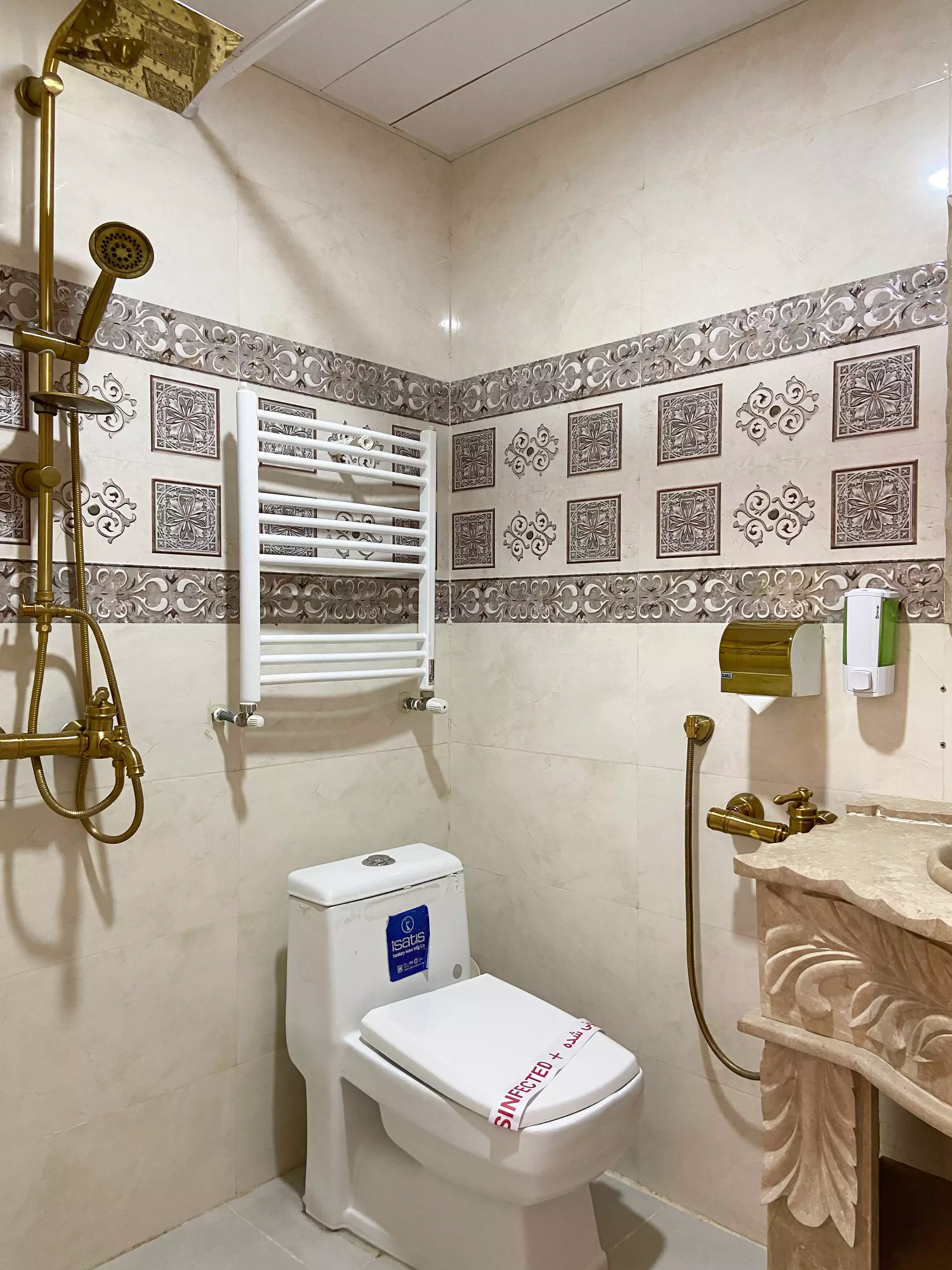 حمام گل آرا با دوش طلایی و حوله‌خشک‌کن دیواری