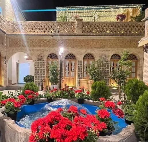 حوض آب و گلهای قرمز حیاط هتل گل آرا