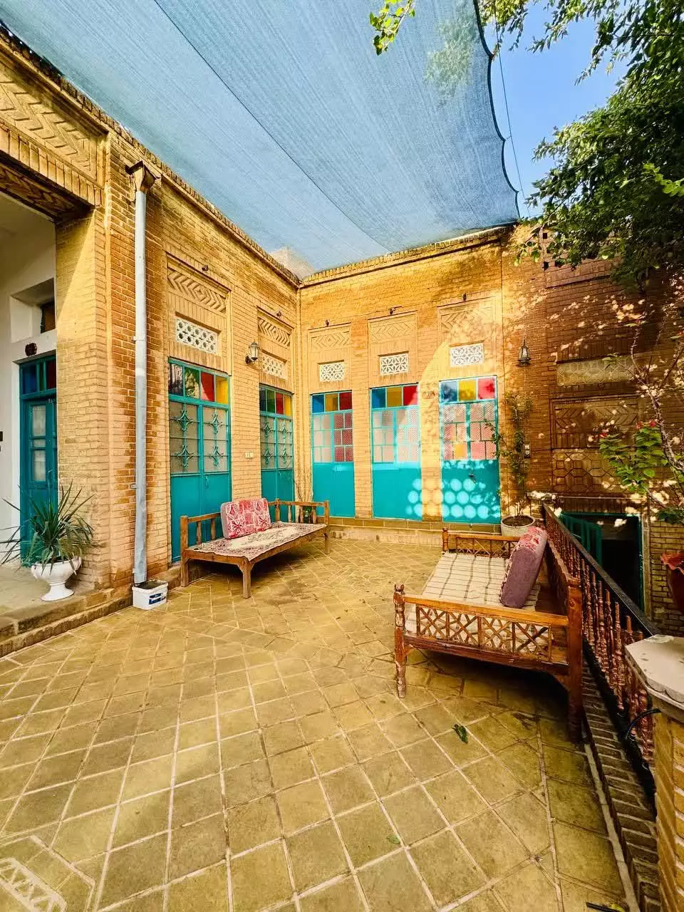 تخت‌های سنتی در حیاط آجری عمارت پدری