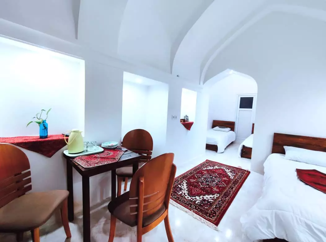اتاق عمارت پدری با تخت‌های سفید و فرش ایرانی