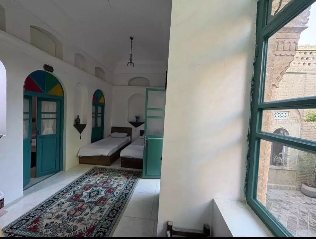 اتاق عمارت پدری با پنجره سبز و فرش ایرانی