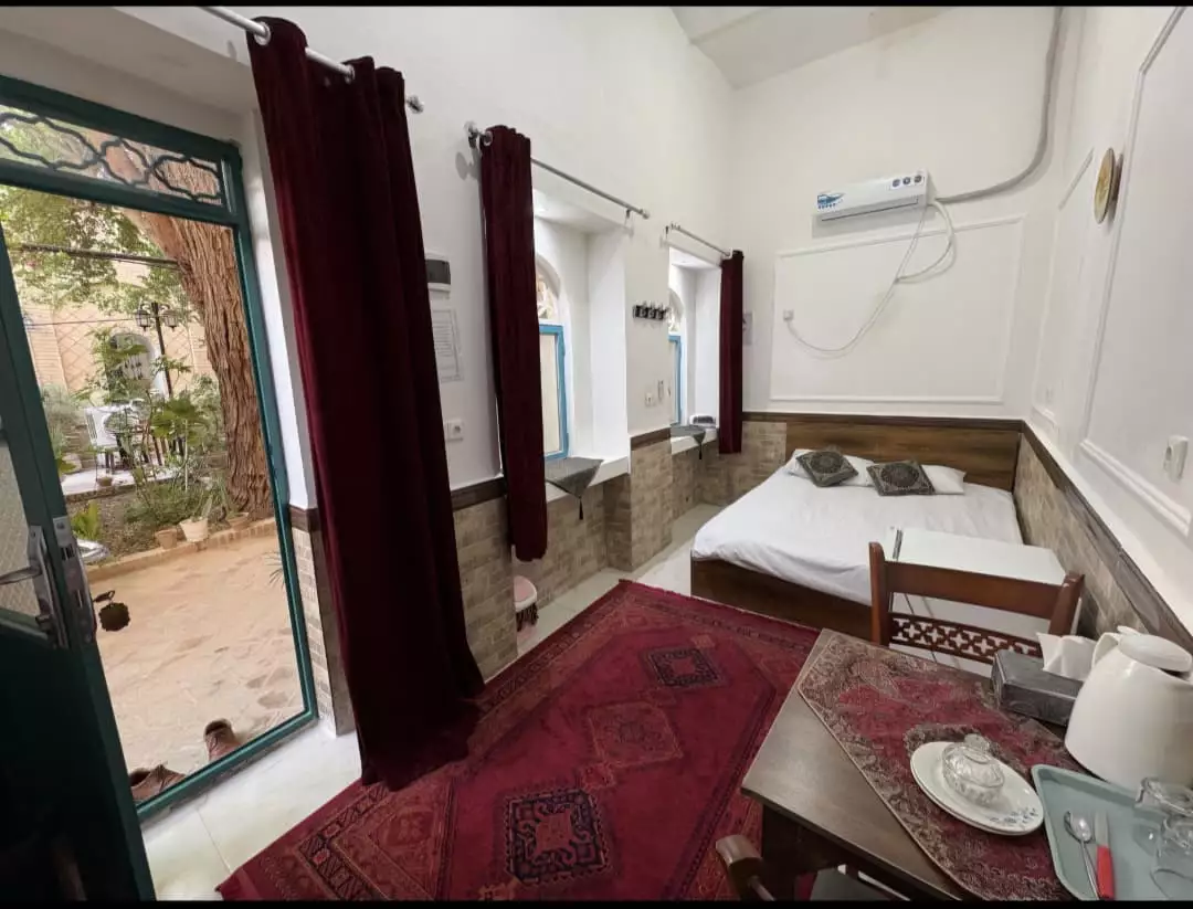 اتاق عمارت پدری با تخت و درِ رو به حیاط