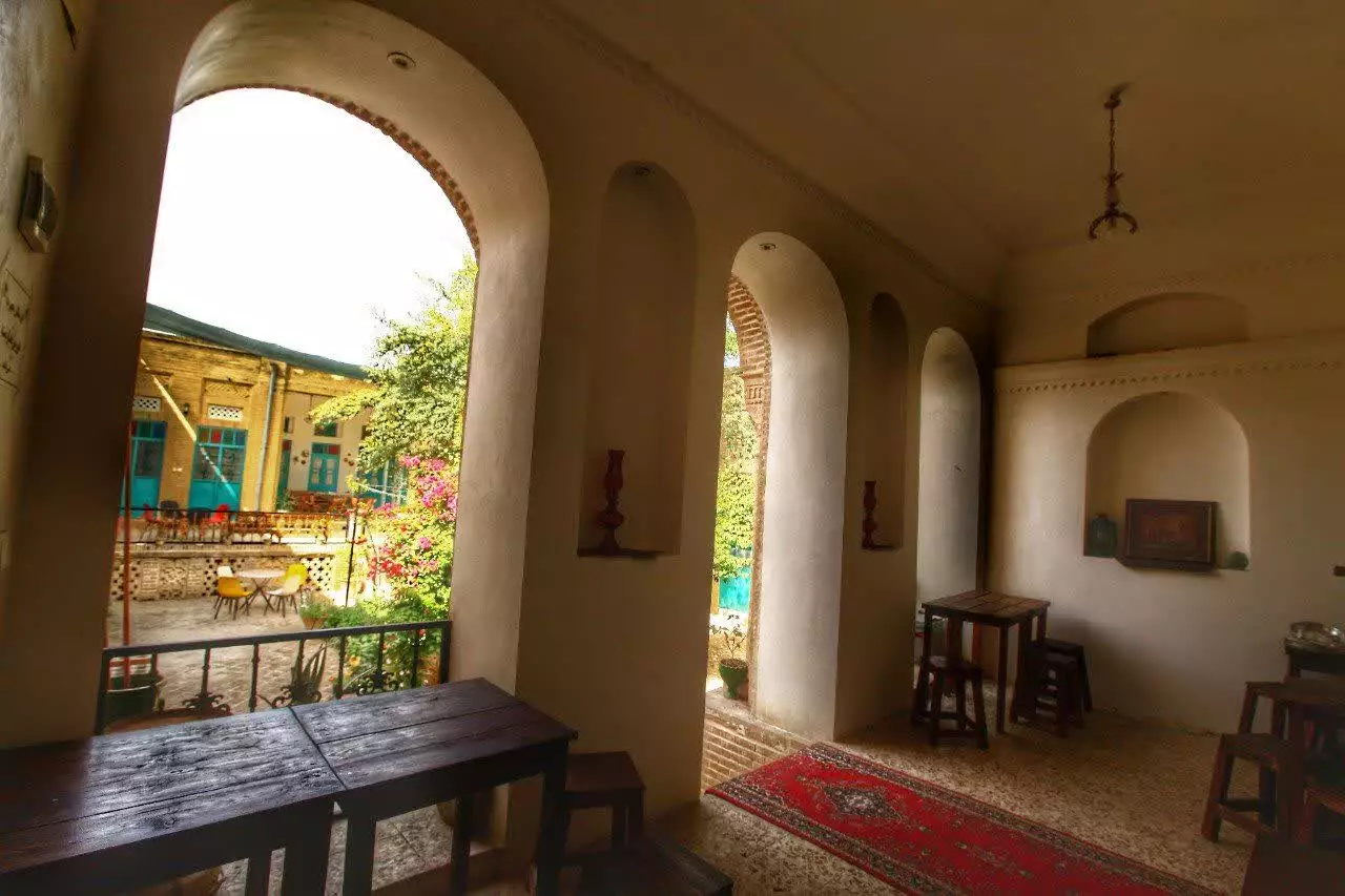 ایوان طاق‌دار و میزهای چوبی عمارت پدری