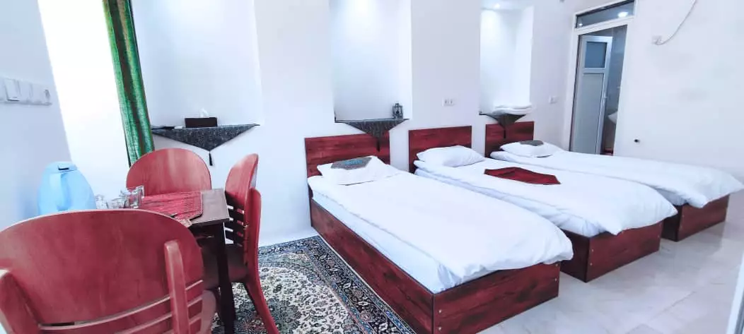 اتاق عمارت پدری با سه تخت و صندلی‌های قرمز
