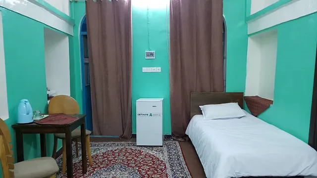 اتاق عمارت پدری با تخت یک‌نفره و دیوارهای فیروزه‌ای