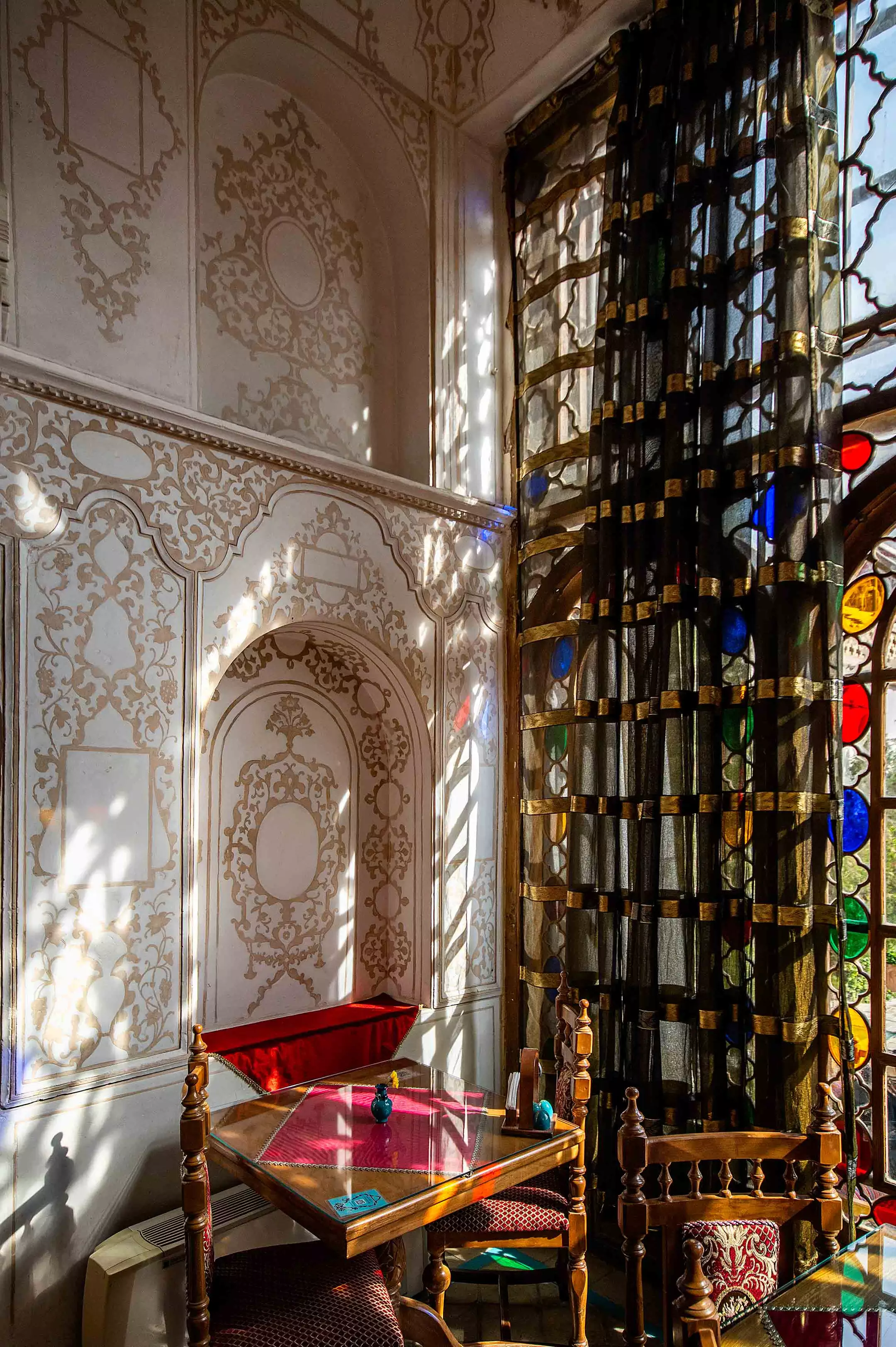 پنجره رنگی و میز چوبی در قصر منشی