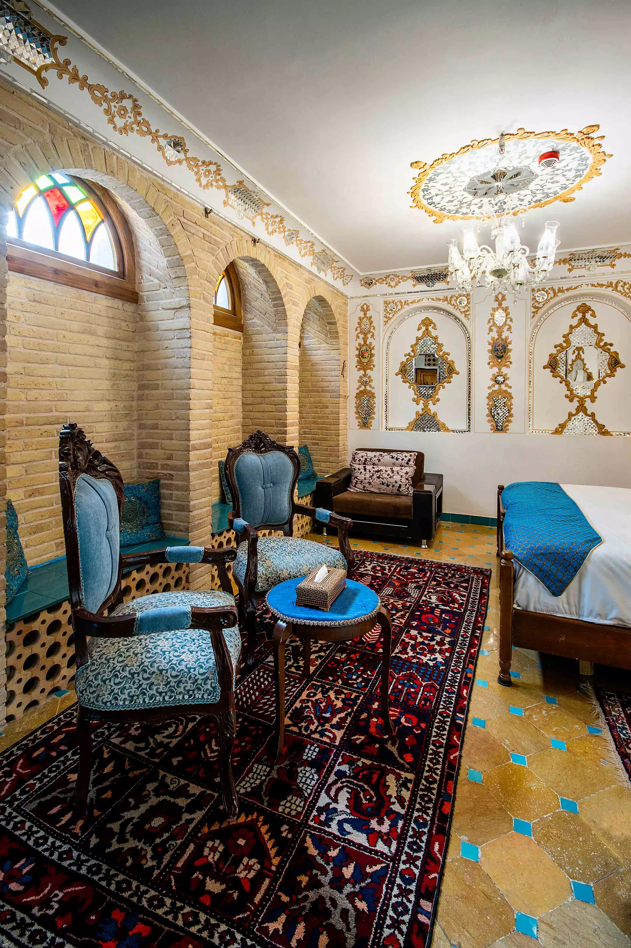 اتاق خواب با صندلی‌های سنتی و فرش ایرانی در قصر منشی
