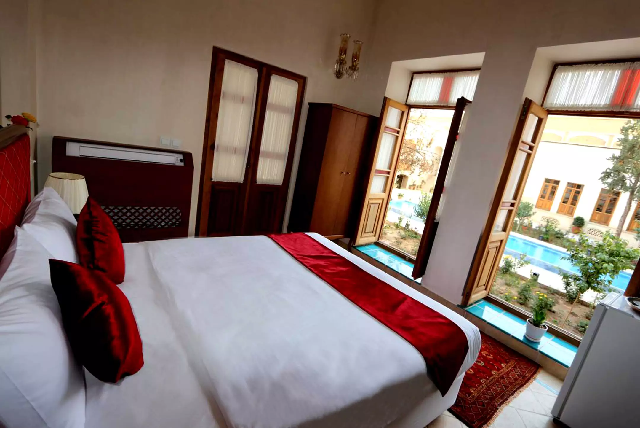 اتاق خواب عمارت ماندگار با پنجره رو به حیاط