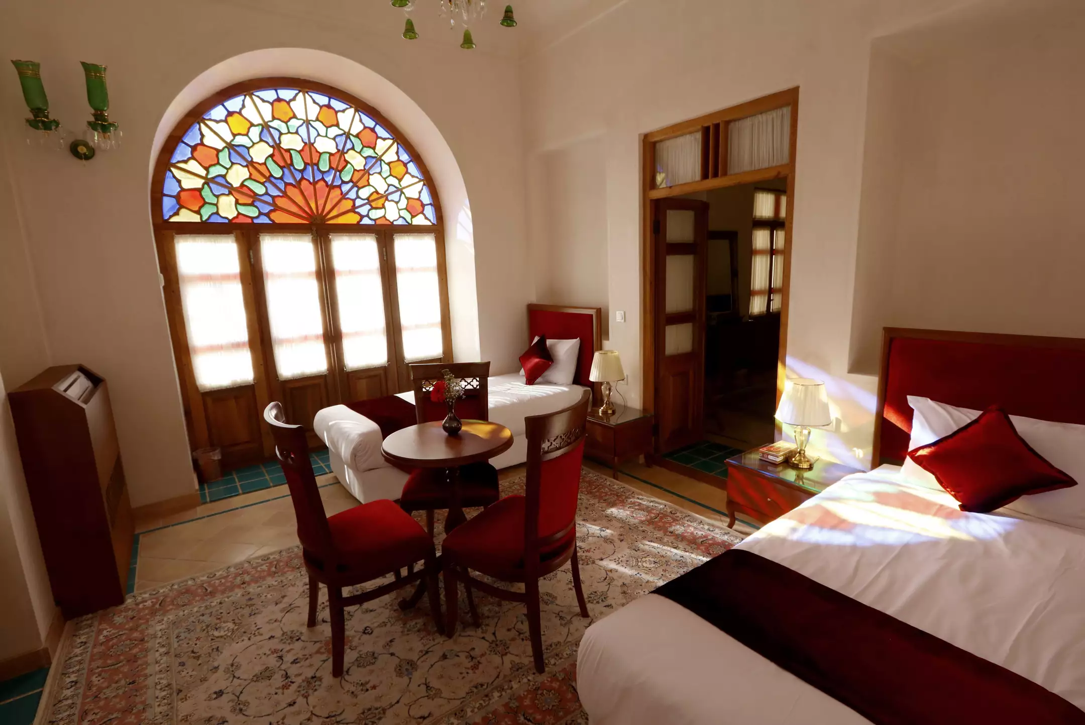 اتاق عمارت ماندگار با پنجره شیشه‌رنگی و تخت