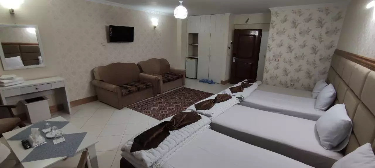 اتاق دو‌تخته با تخت‌های جدا و مبلمان هتل بهارستان