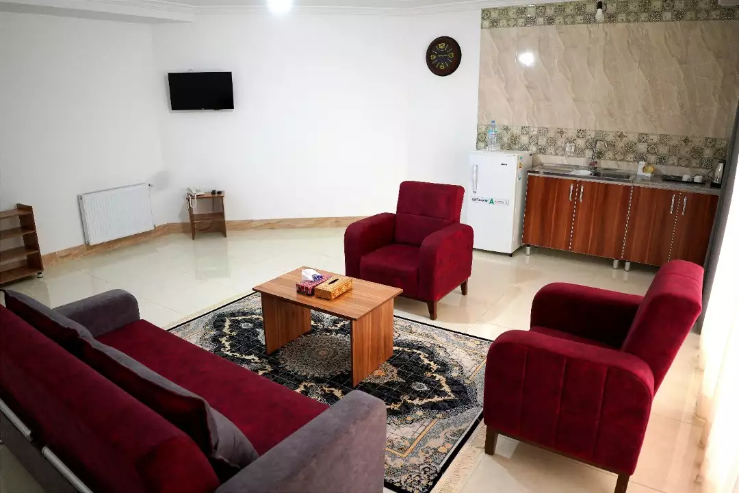 نشیمن هتل جهان با مبلمان زرشکی و آشپزخانه