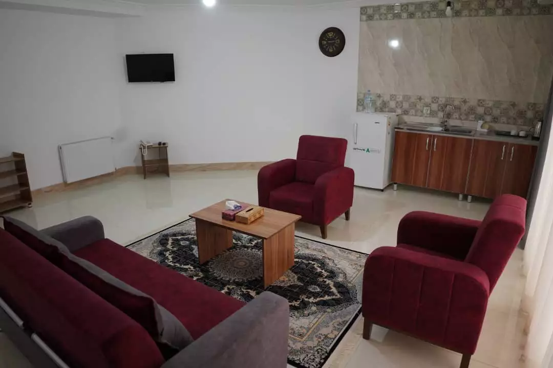 نشیمن هتل جهان با مبلهای زرشکی و میز چوبی