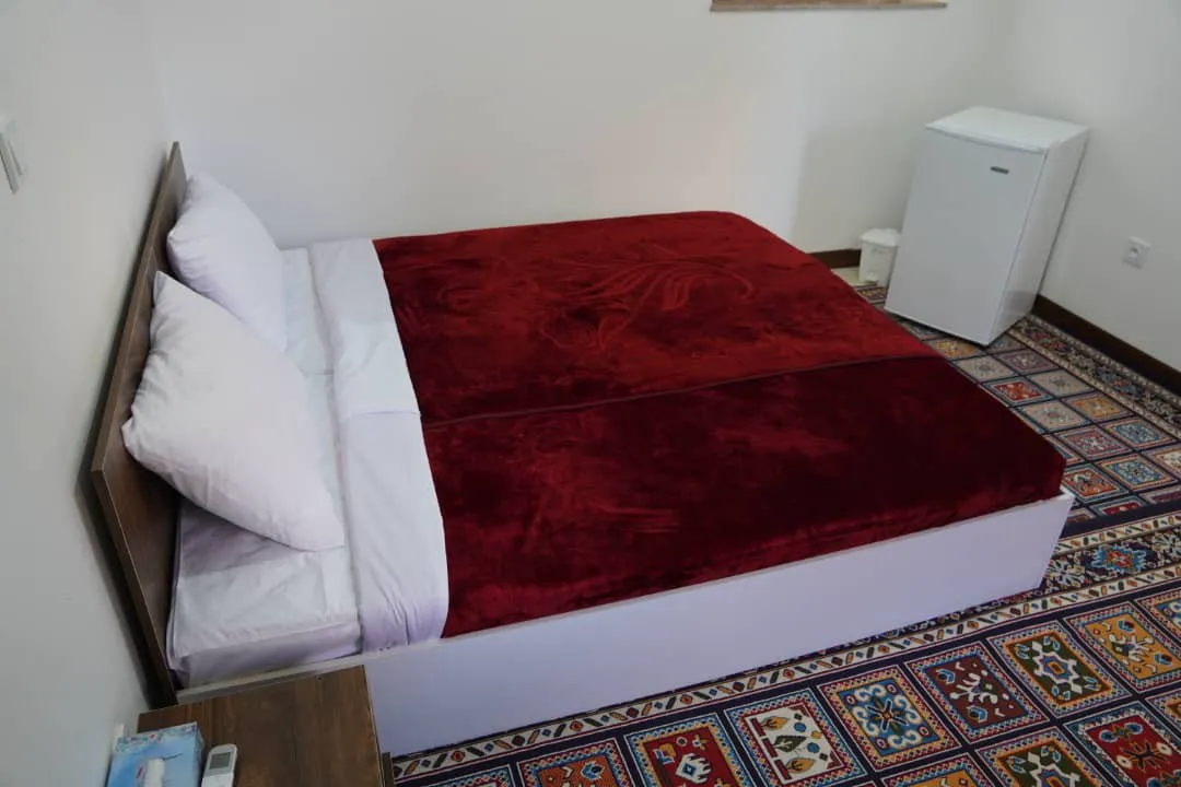 تخت دونفره با روتختی زرشکی در هتل پایاب