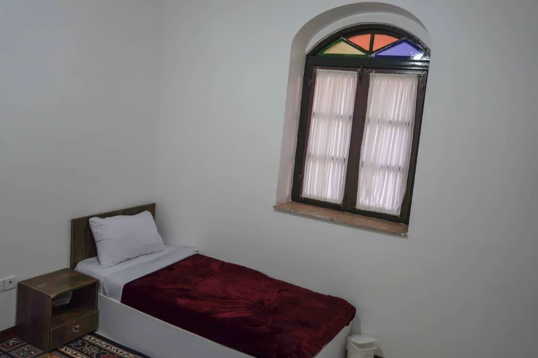 تخت یک‌نفره کنار پنجره رنگی هتل پایاب
