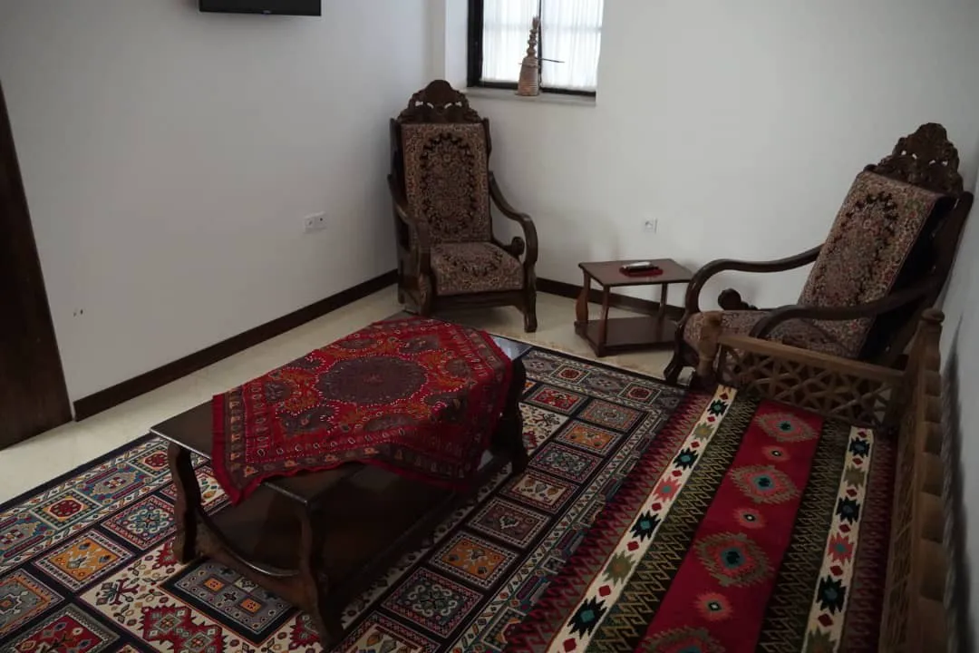 اتاق نشیمن با مبلمان چوبی و فرش سنتی هتل پایاب