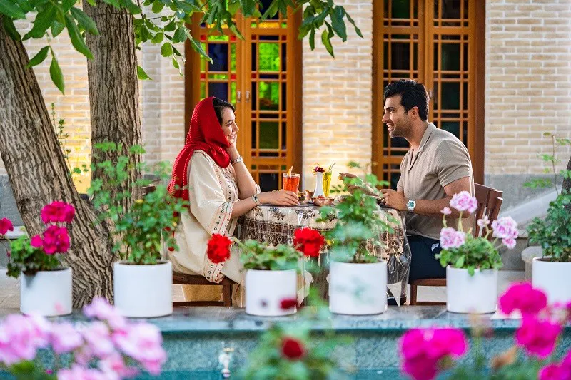 زوجی در حال گفتوگو در حیاط کافه