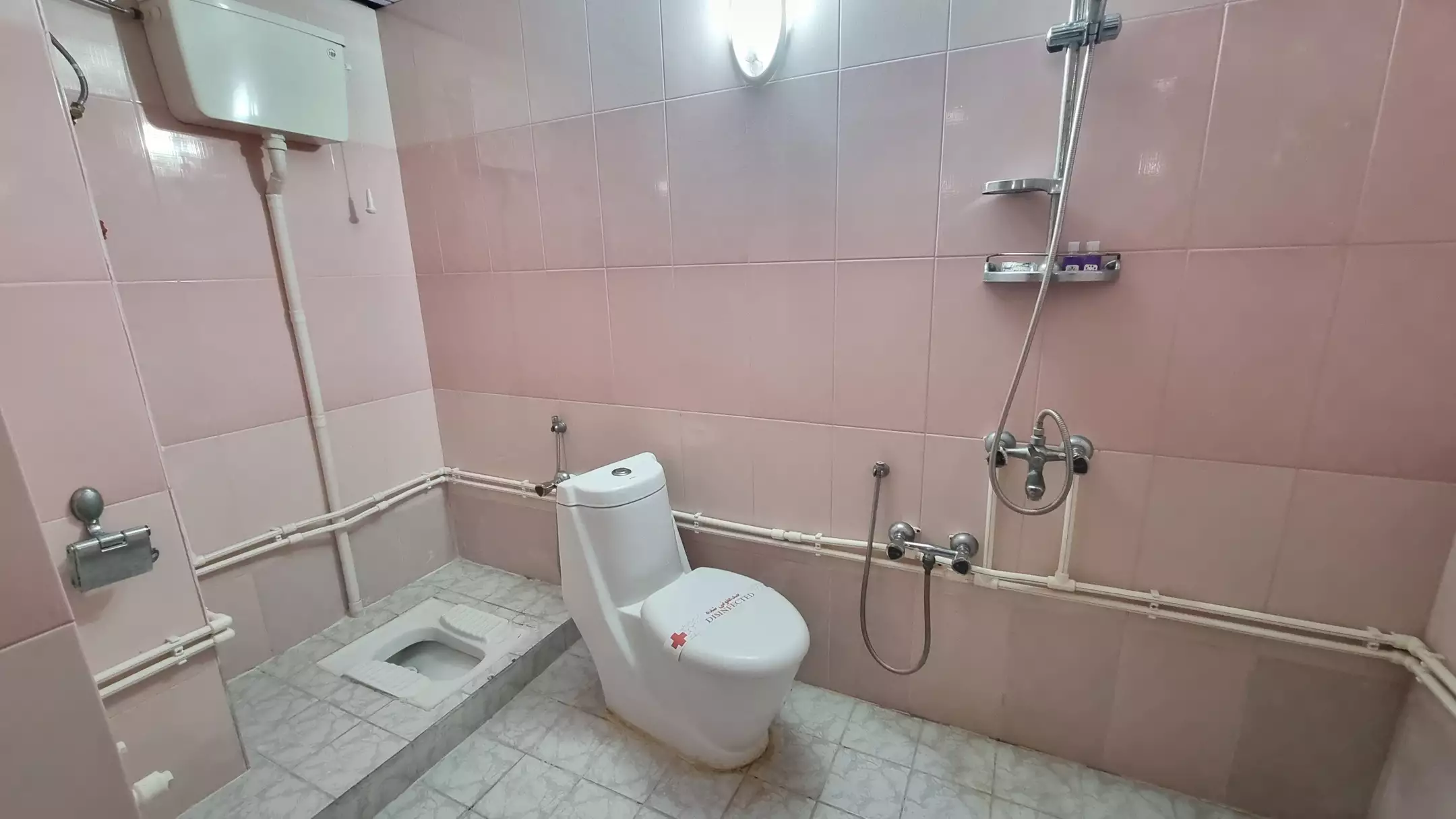 سرویس بهداشتی ایرانی و دوش با کاشی صورتی در هتل تماشا