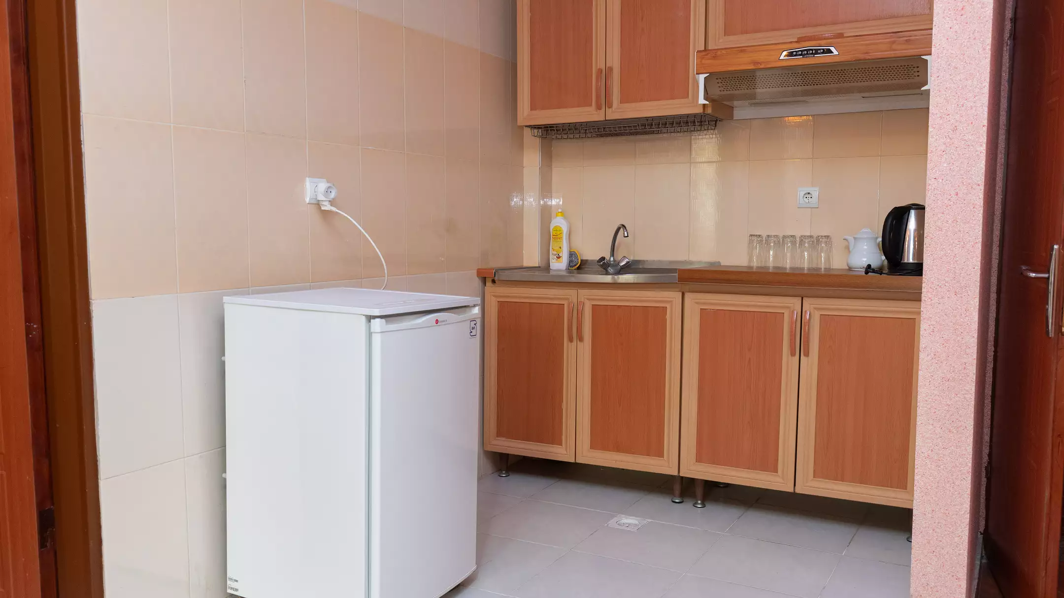 آشپزخانه با کابینت چوبی و یخچال هتل تماشا