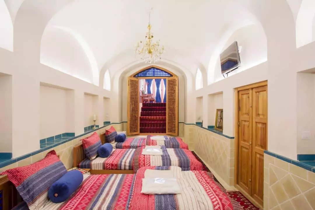 اتاق خواب هتل سرپله با تخت‌های سنتی رنگارنگ