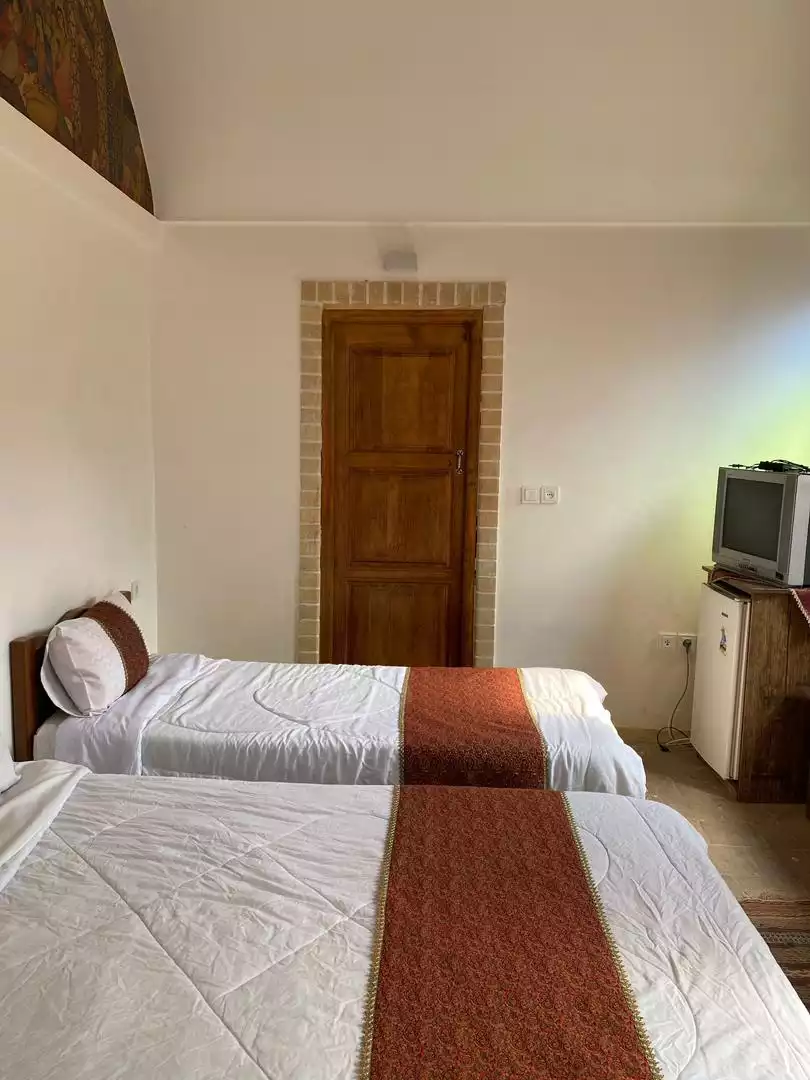 دو تخت یک‌نفره در اتاق سرای کهن