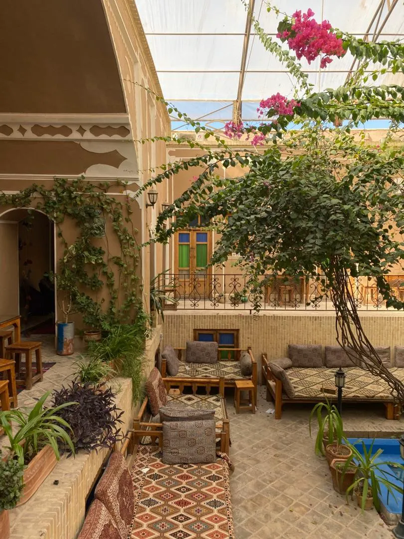 حیاط سرای کهن با نشیمن سنتی و گیاهان رونده