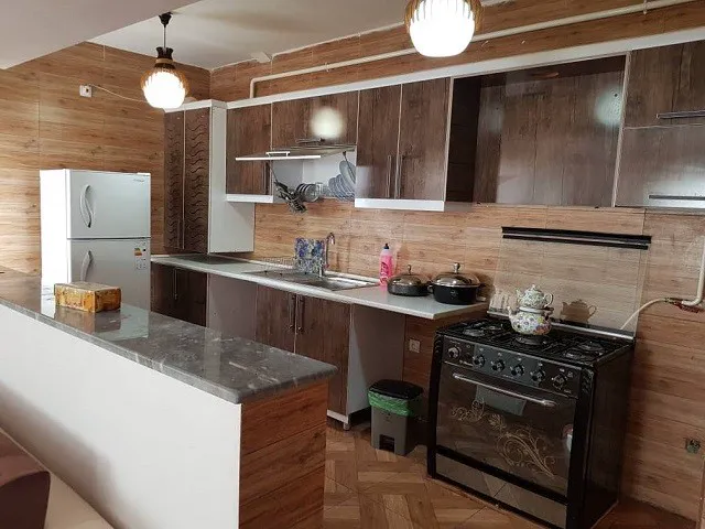 آشپزخانه هتل یاس با کابینت چوبی و اجاق