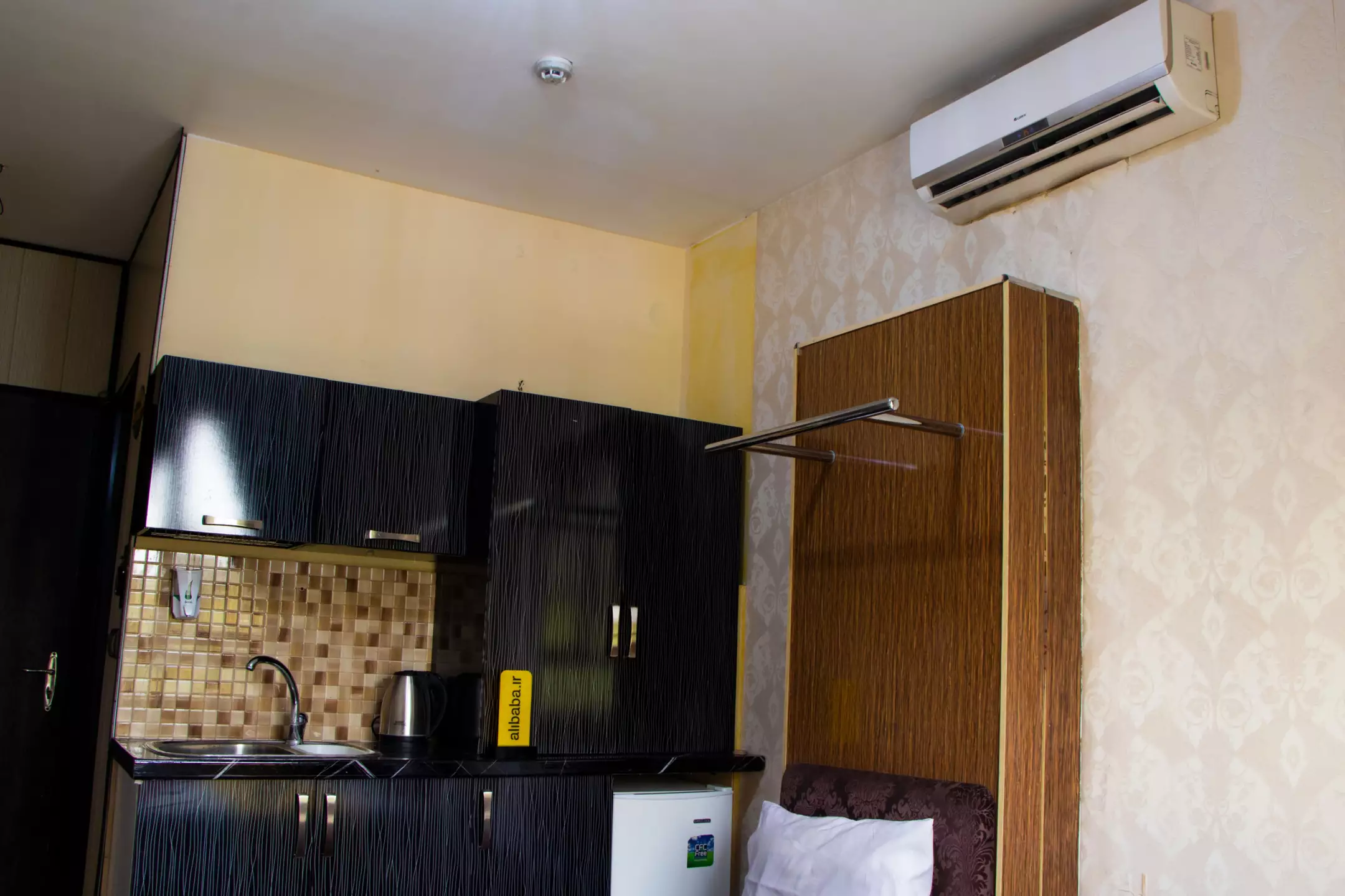 آشپزخانه کوچک اتاق هتل آتوسا با کابینت و یخچال