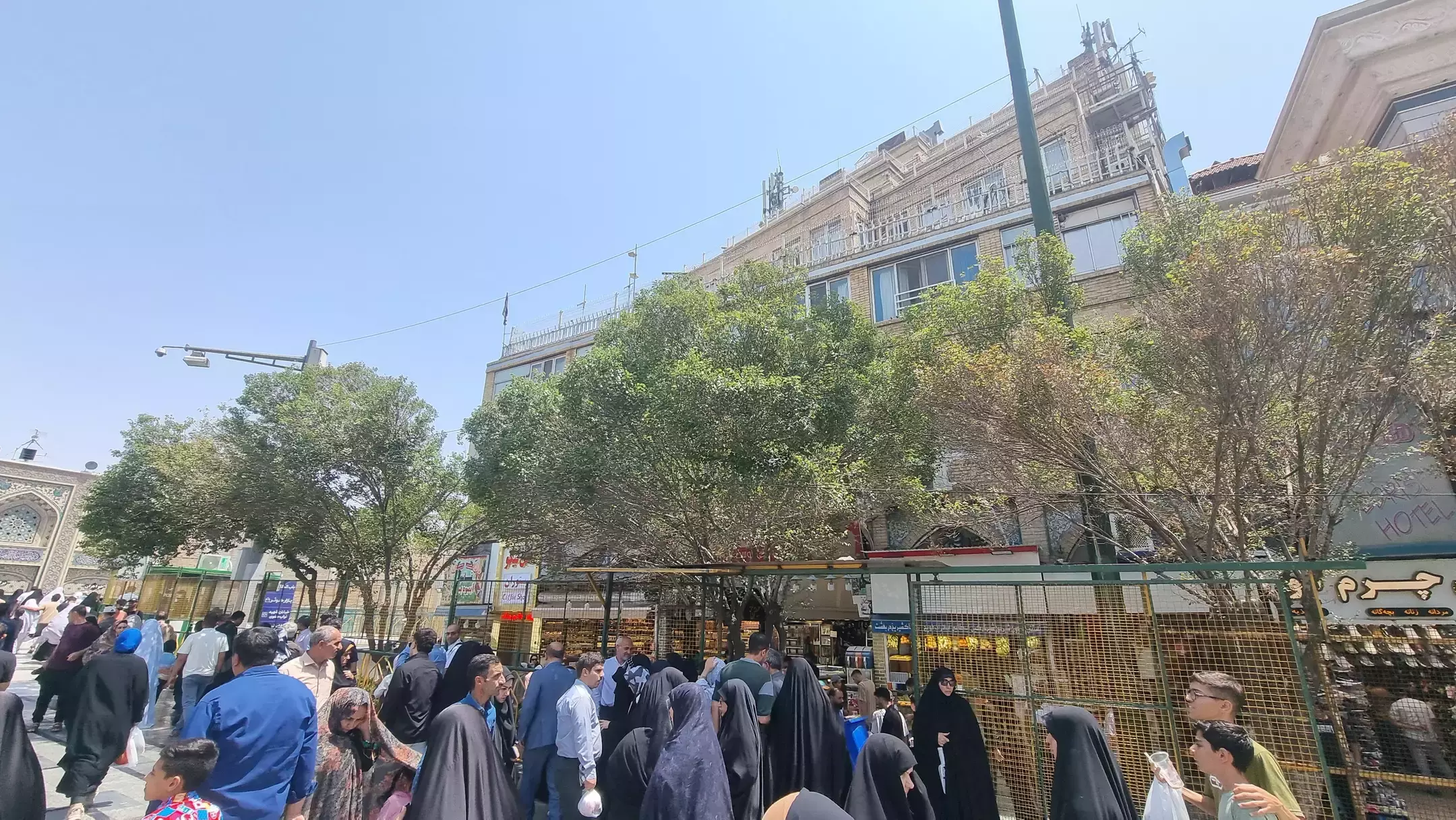 جمعیت در خیابان شلوغ کنار مغازه‌ها