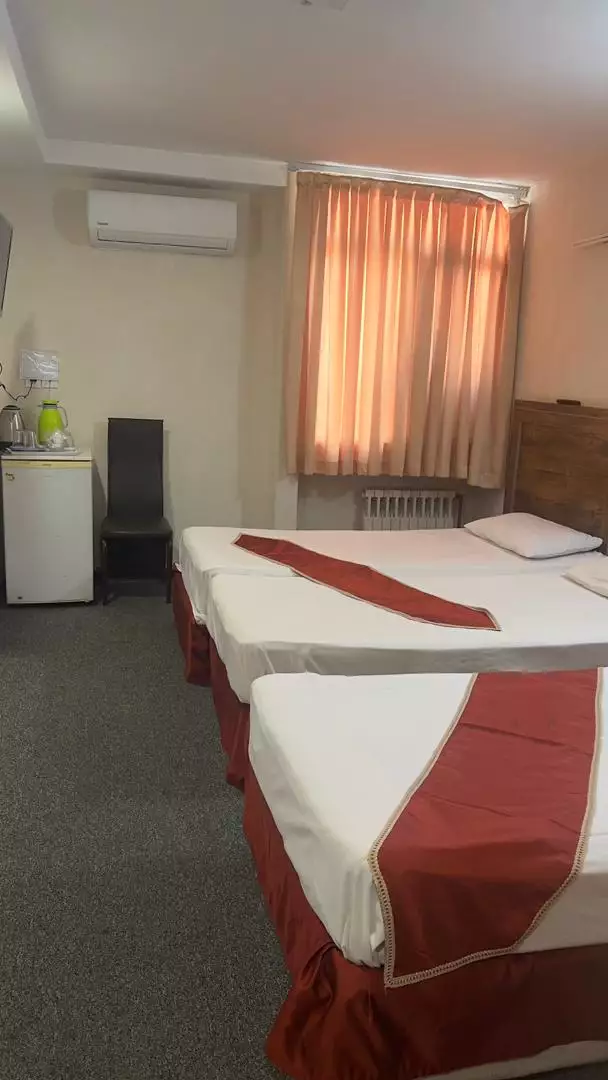 اتاق هتل بستان با تخت دونفره و پرده نارنجی