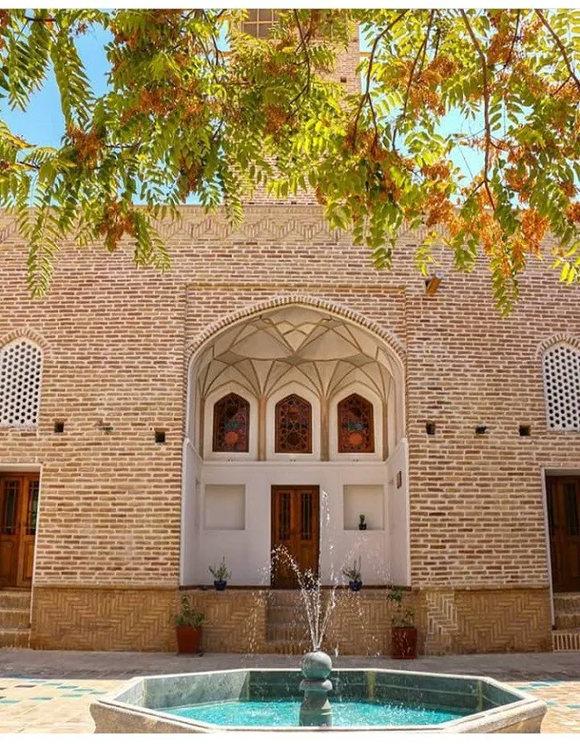 نمای آجری هتل اسفنجان با حوض و درختان