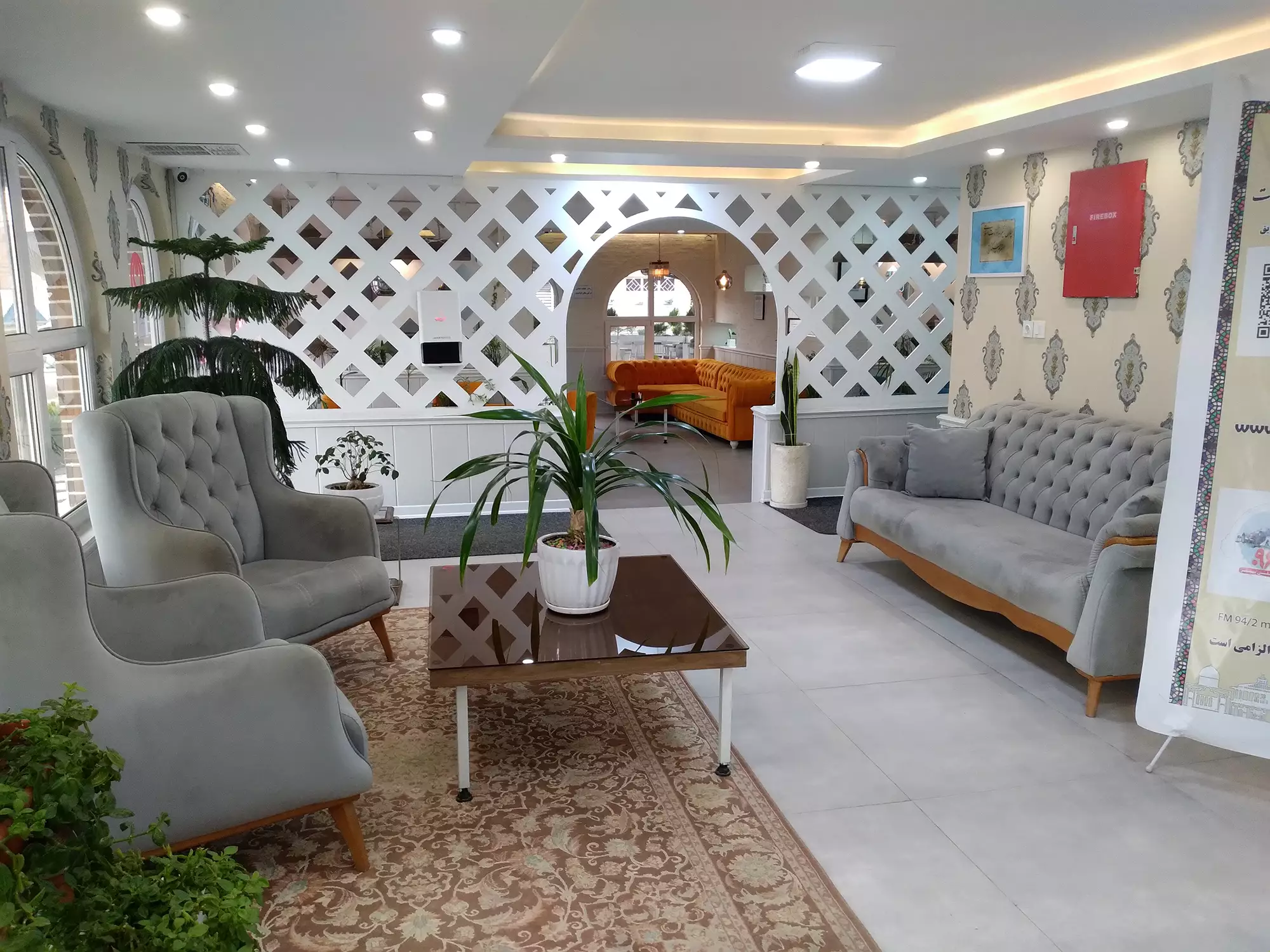 پذیرایی هتل اطلس با مبلهای خاکستری و میز