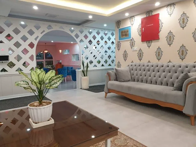 لابی هتل اطلس با مبل طوسی و میز چوبی