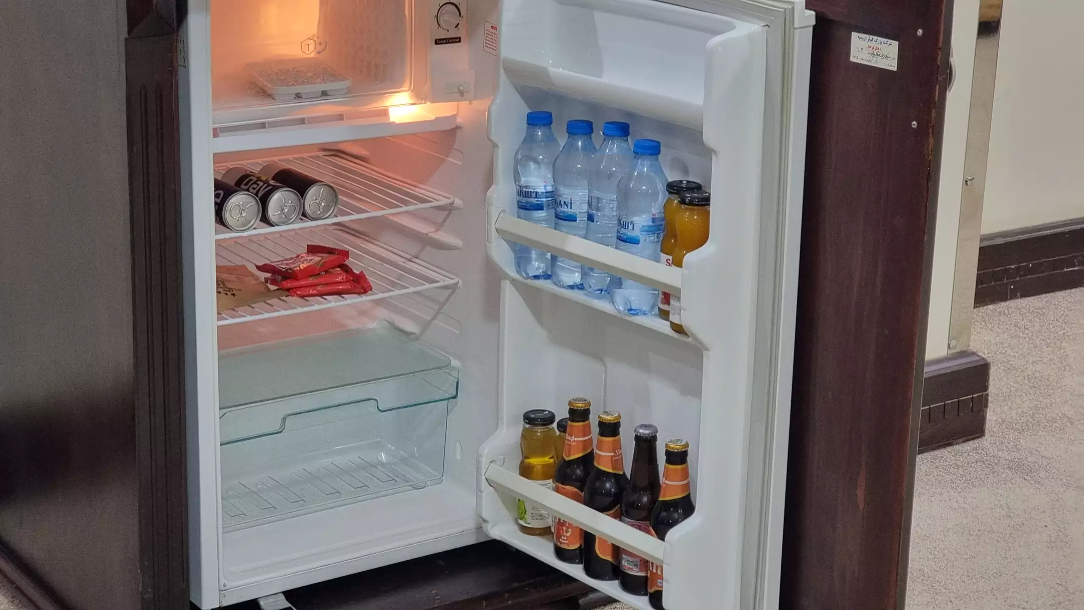 مینی‌بار هتل پارک با بطری‌های آب و نوشیدنی