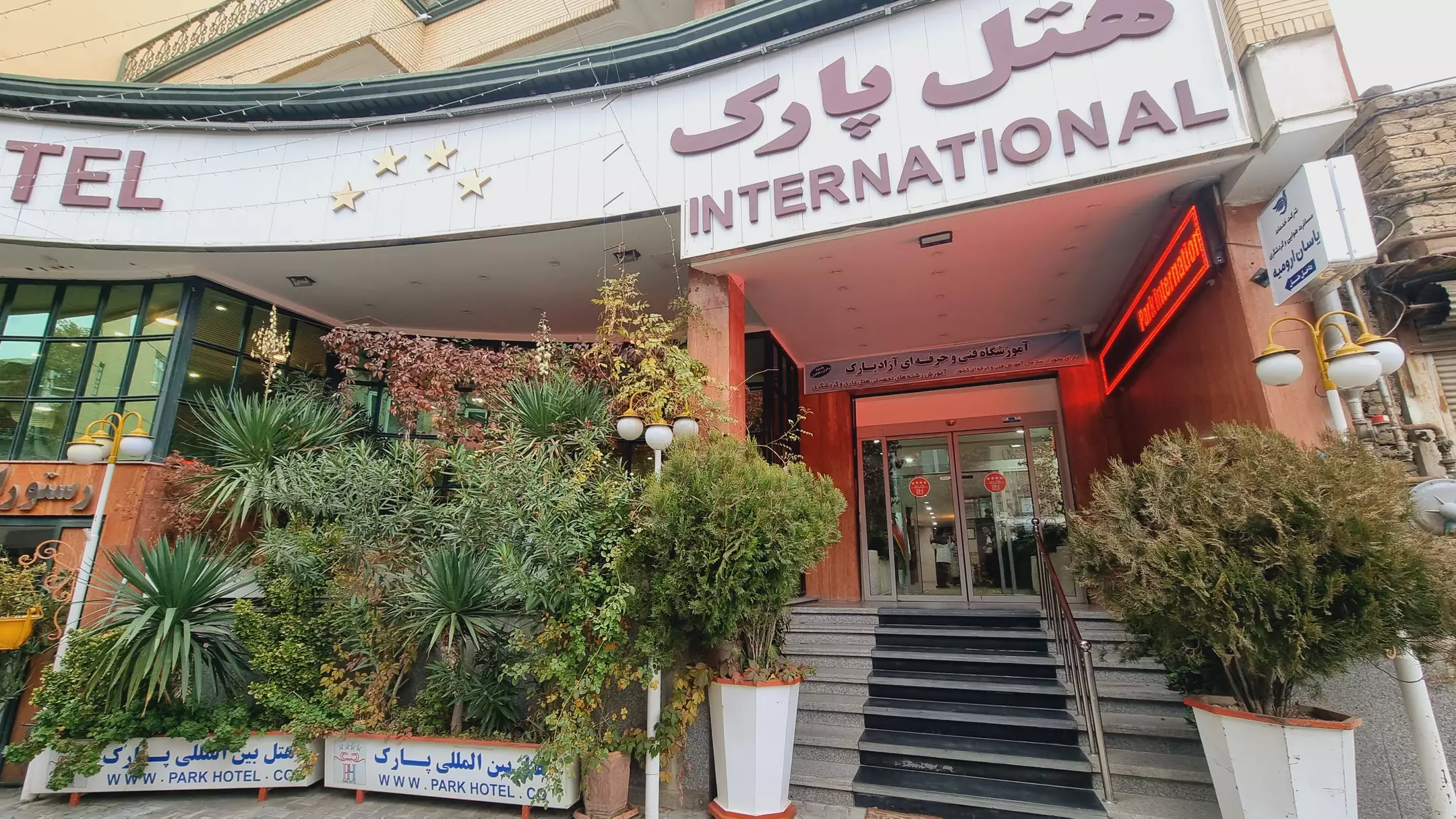 ورودی هتل پارک با پله و فضای سبز گلدانی