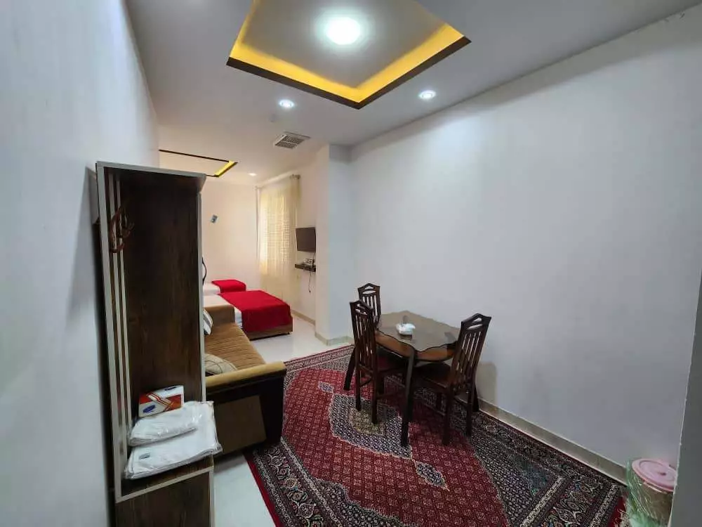 میز غذاخوری و تخت در اتاق هتل متین