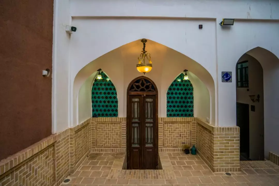 ورودی طاق‌دار با در چوبی در سرای سهراب