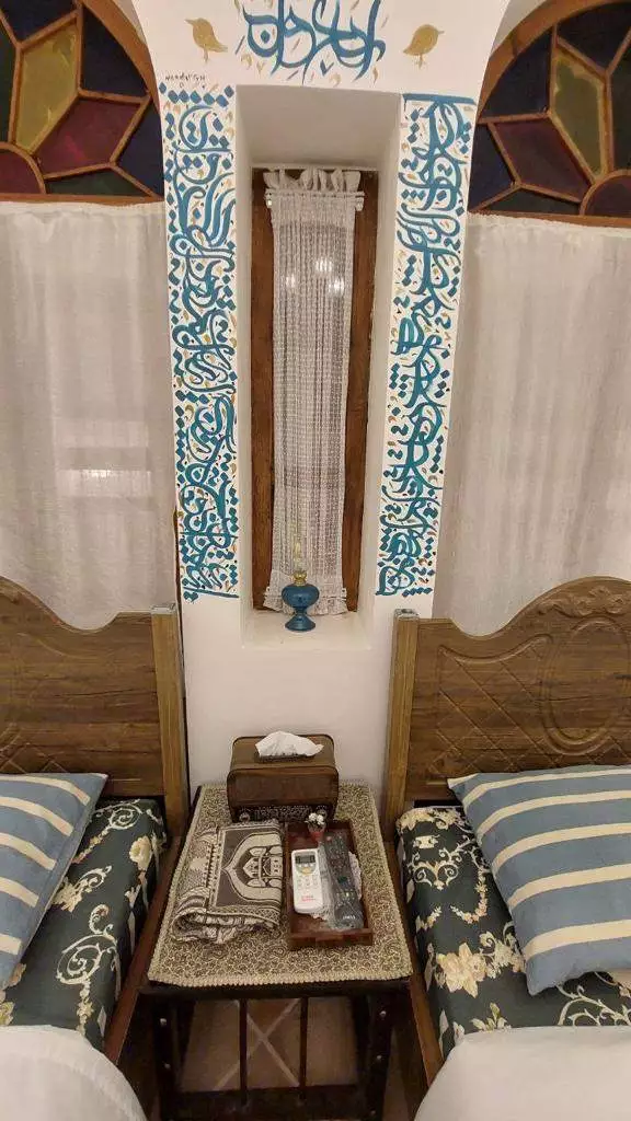 دو تخت یک‌نفره با تزیینات سنتی در سرای سهراب