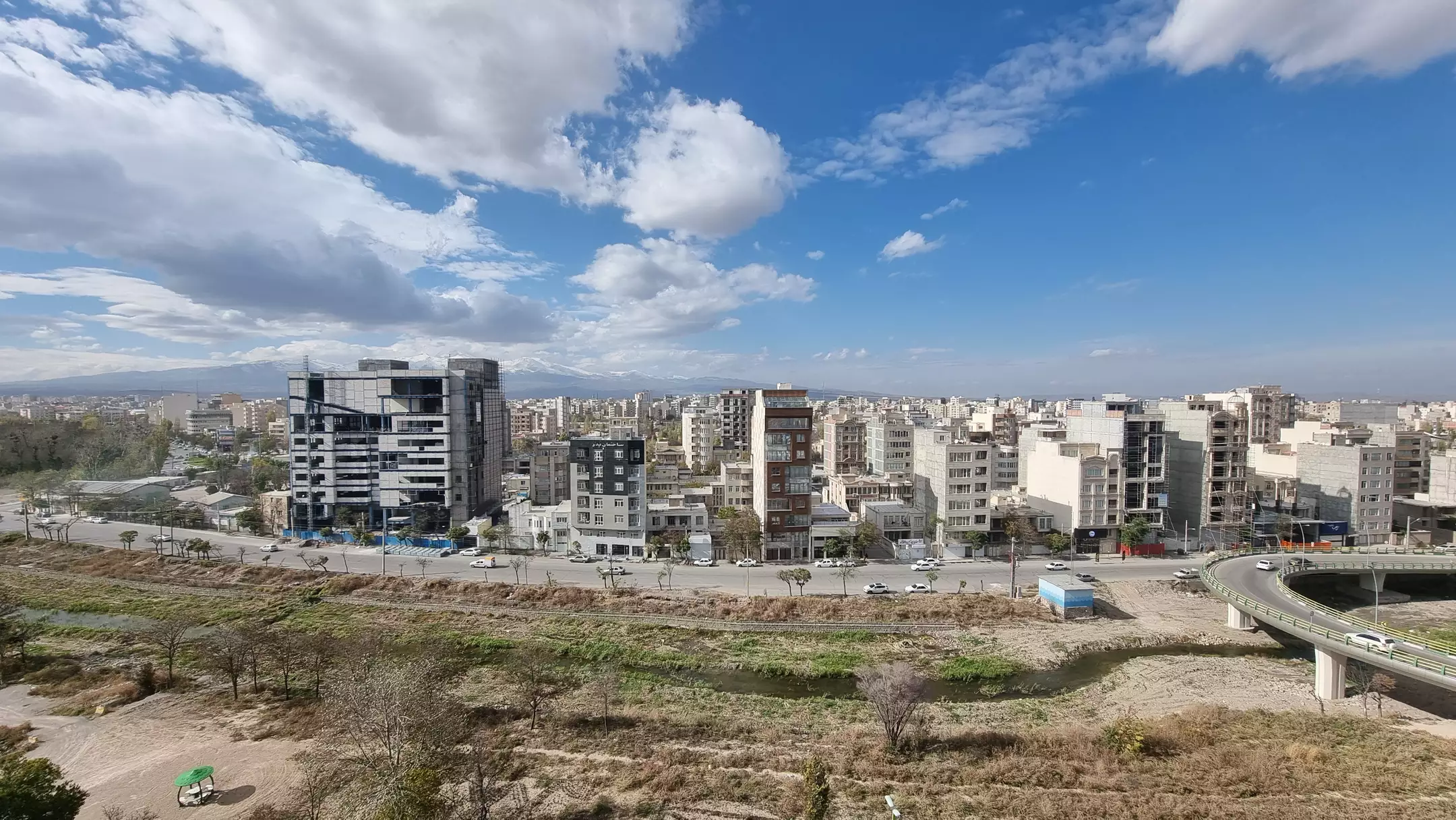 نمای شهر و ساختمان‌های شهری در زیر آسمان ابری