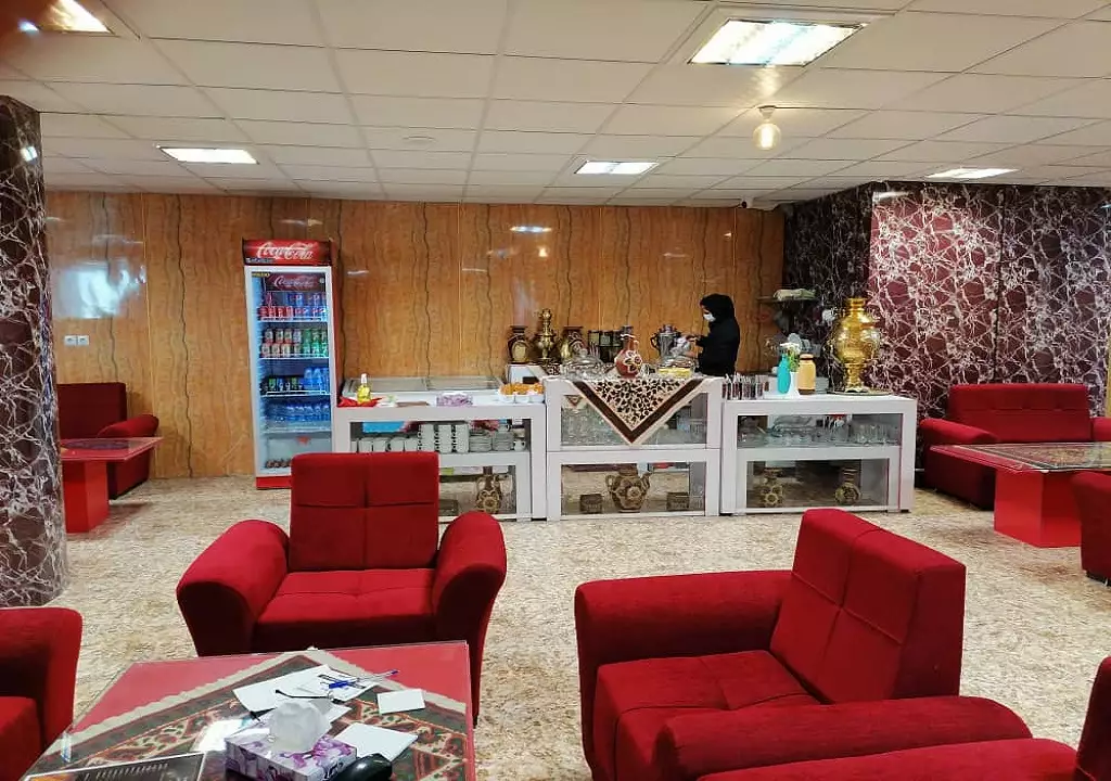 پذیرش هتل پویا با پیشخوان و مبل‌های قرمز